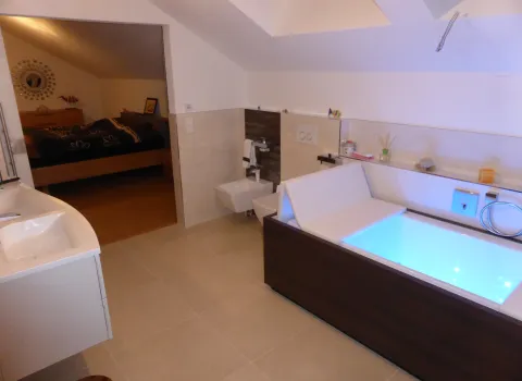 Ein blau beleuchteter Whirlpool im Badezimmer.