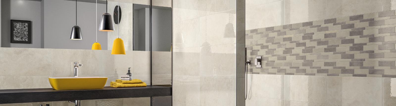 Badezimmer im Fliesenmix und großem Spiegel